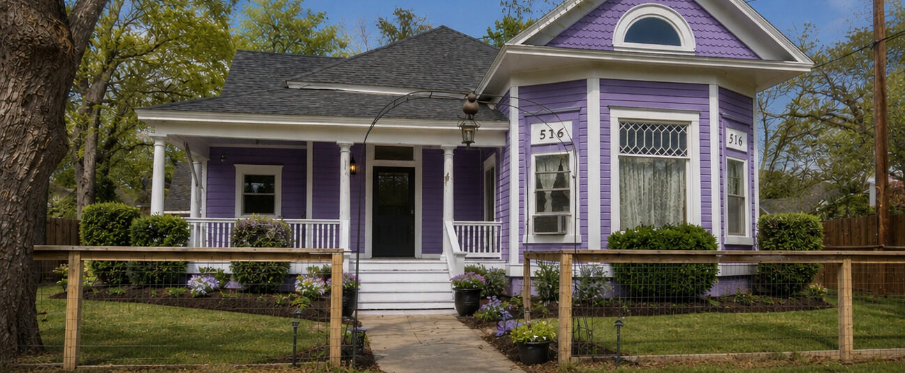 Historic Victorian home repainted in violet with bright white trim and porch details